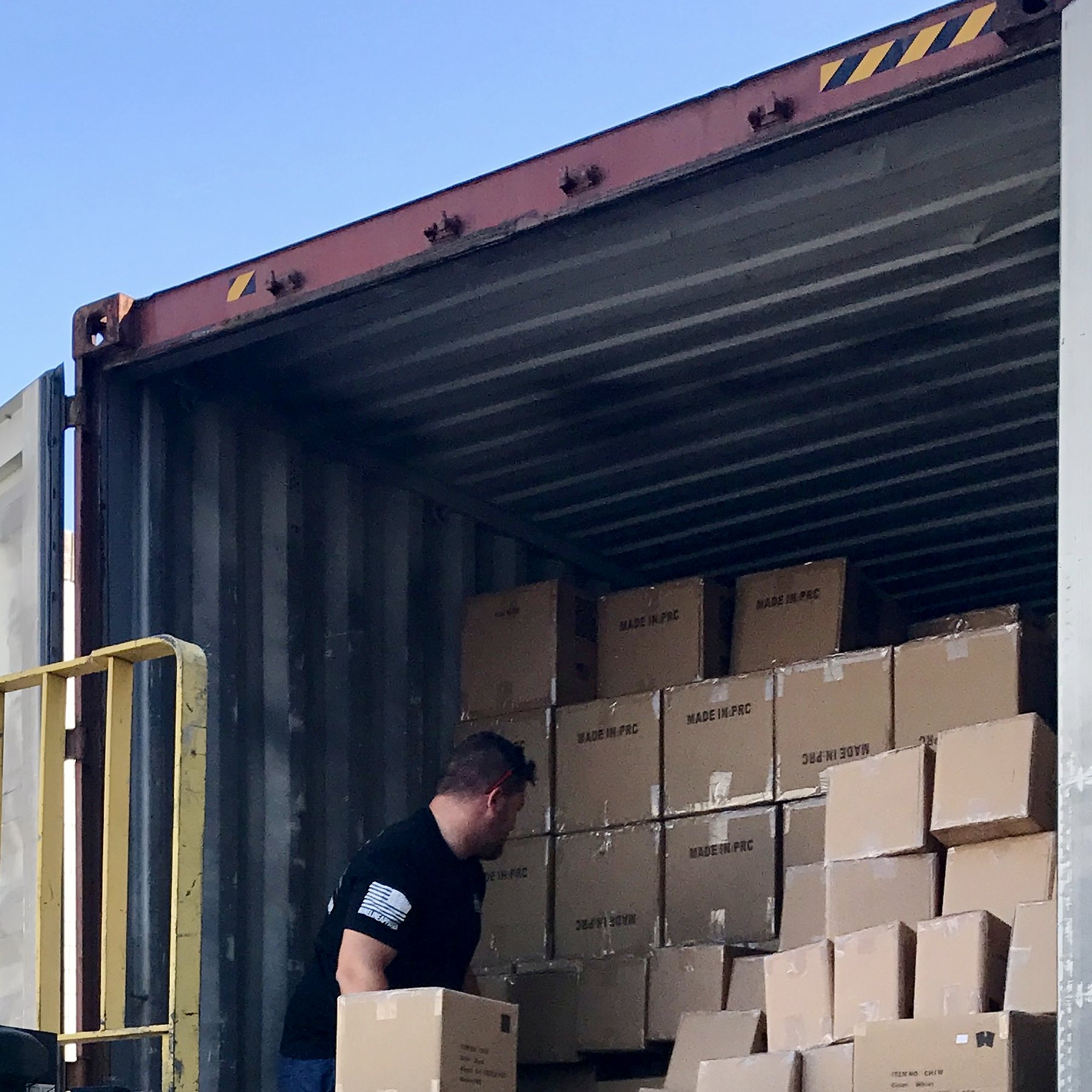 Cartons marked Made in PRC stacked inside a shipping container
